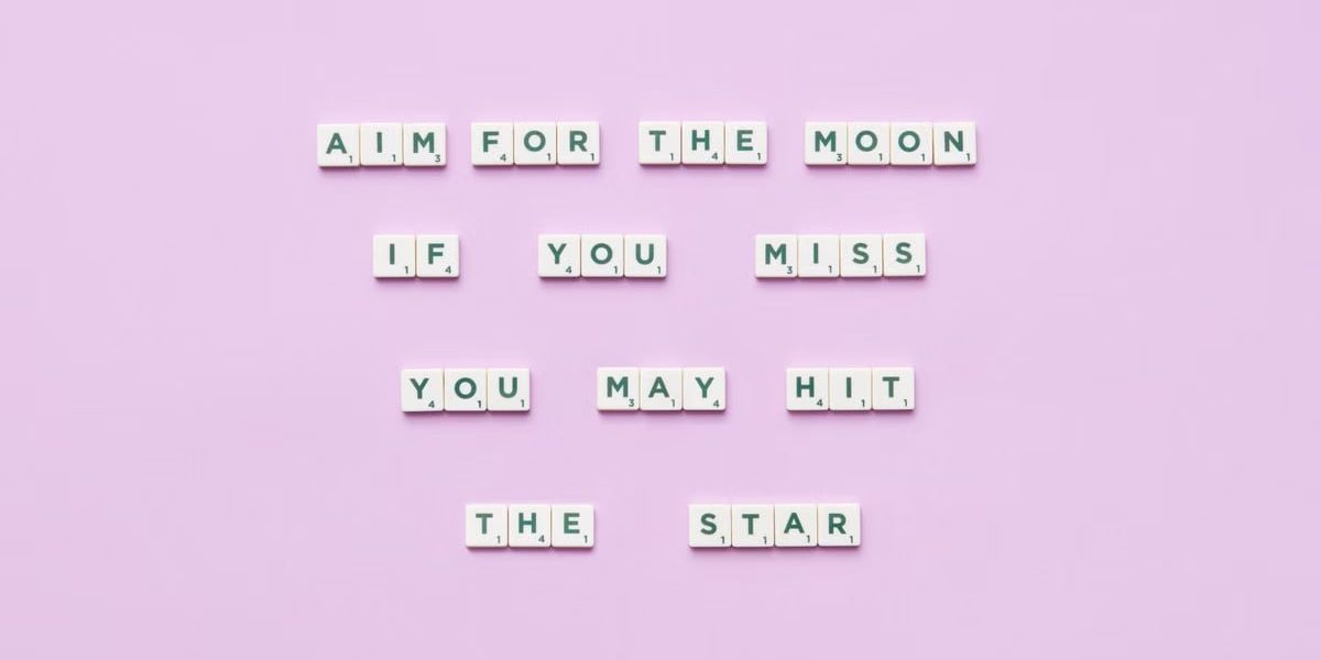 Inspirational message using Scrabble tiles on a pastel background.