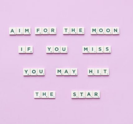 Inspirational message using Scrabble tiles on a pastel background.